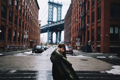 Woman on bridge in city against sky