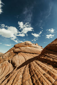 Wave pattern of red rock petrified sand dunes under blue sky in desert