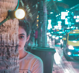 Portrait of woman with illuminated lights at night