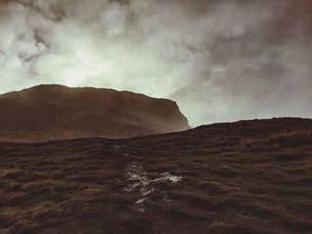 Scenic view of mountains against cloudy sky