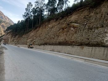 Road by trees on mountain