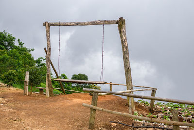 Low angle view of rusty metallic structure on field against sky