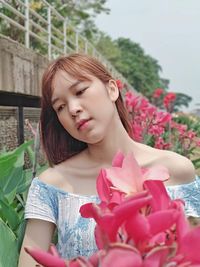 Low angle view of woman with pink roses