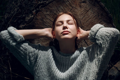 High angle view of woman lying on tree stump