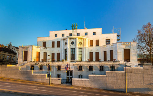 Buildings in city against clear blue sky