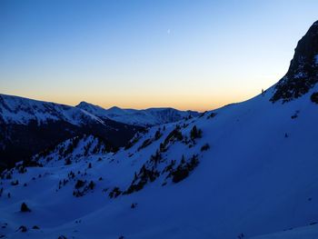 Scenic view of snowcapped mountains against clear sky during winter