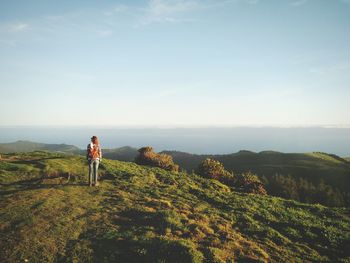 Woman standing on landscape against sky