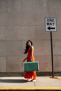 A smiling woman holding her suitcase 