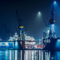 Illuminated commercial dock against sky at night