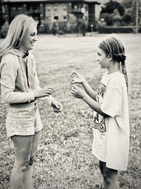 Side view of mother and daughter talking in the park.