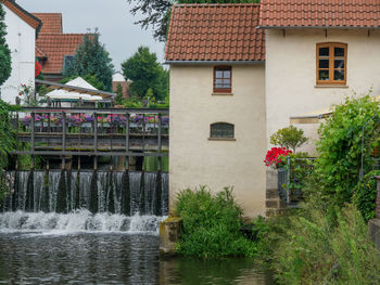 Houses by river and buildings in city