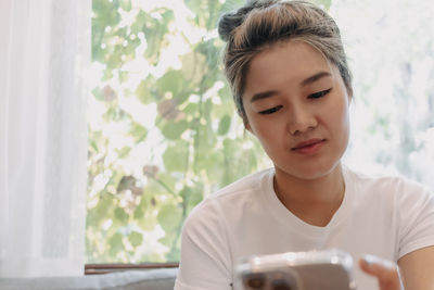 Portrait of young woman drinking coffee at home
