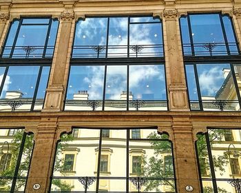 Low angle view of glass building against sky