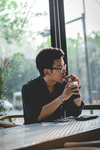 Young man drinking coffee at restaurant