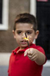 Portrait of boy holding burning sparklers