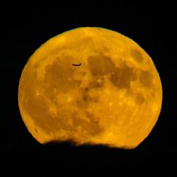 Close-up of yellow moon against sky at night