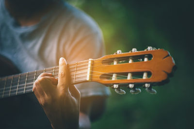 Midsection of person playing guitar