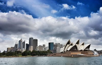 Buildings in city against cloudy sky