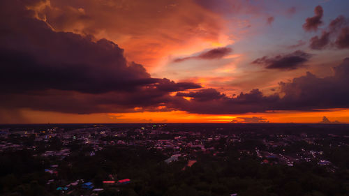 Aerial view of buildings against dramatic sky during sunset