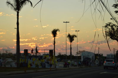 Road in city against sky at sunset