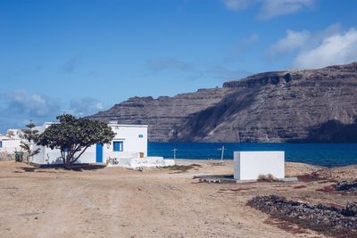 Scenic view of beach by buildings against sky