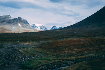 Scenic view of mountains against cloudy sky