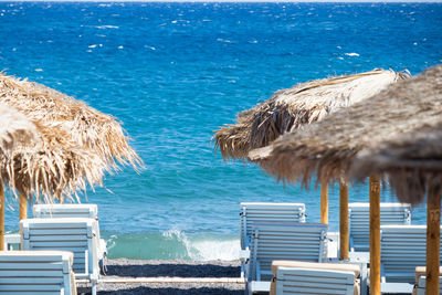 Lounge chairs on beach against sea