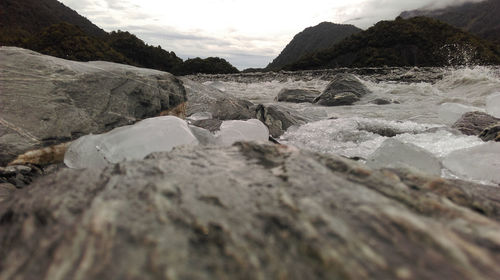 Surface level of rocks on land against sky