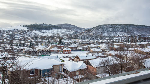 Snow covered houses against sky