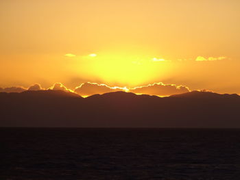 Scenic view of sea against romantic sky at sunset