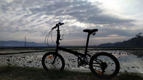 Bicycle on field against sky
