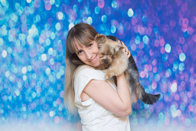 Portrait of happy woman standing against blue sky