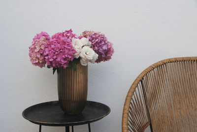 Close-up of flower pot on table against wall