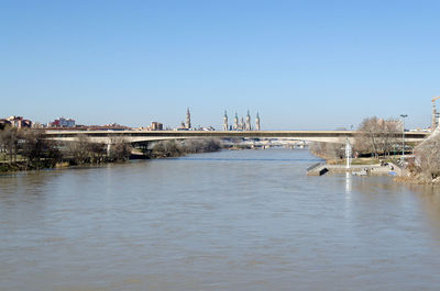 Bridge over river against clear blue sky