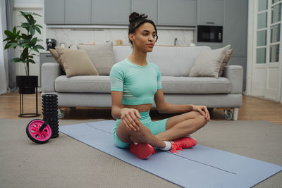 Portrait of young woman sitting on sofa at home