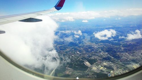 Aerial view of clouds over landscape seen from airplane