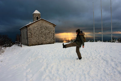 Full length of man on snow covered field against sky