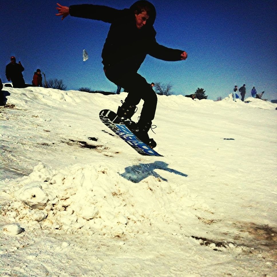 full length, lifestyles, leisure activity, mid-air, sand, beach, casual clothing, jumping, enjoyment, fun, clear sky, young adult, carefree, sky, standing, arms outstretched, person, freedom