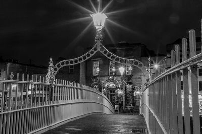 Low angle view of illuminated bridge against sky at night