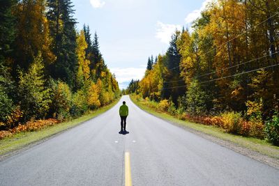 Rear view of man walking on road