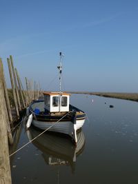 Boat moored in lake against sky