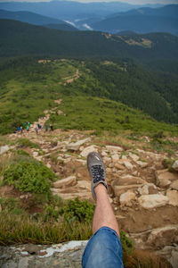 Low section of man standing on mountain