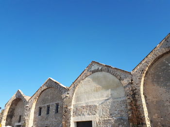 Low angle view of historic building against clear blue sky