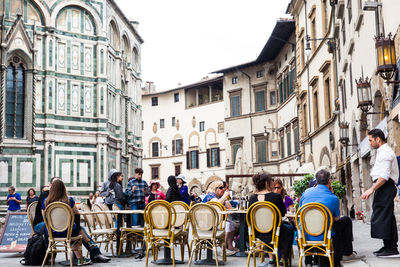 People on street against buildings in city