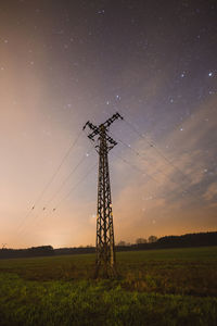 Windmill on field against sky at night