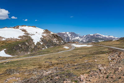 Scenic view of snowcapped mountains against blue sky