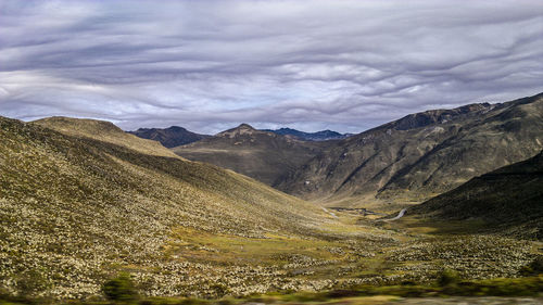 Scenic view of mountains against cloudy sky