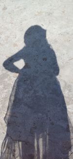 High angle view of shadow of person standing on sunny day
