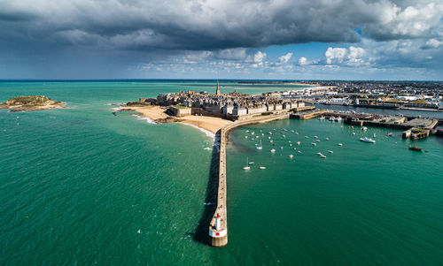 High angle view of boats in sea against cloudy sky