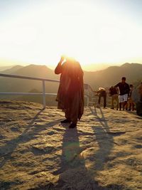 Woman standing on mountain at sunset